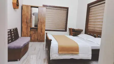 a bedroom with a bed and a window and a mirror at UPPU HOMESTAY in Mulappilangād