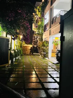 a narrow street with plants on the side of a building at UPPU HOMESTAY in Mulappilangād