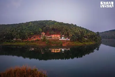 a house on an island in the middle of a lake at StayVista at Lagoons Villa with Lawn, Pool, WiFi in Kozhikode