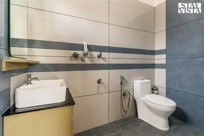 a bathroom with a toilet and a sink at StayVista at Lagoons Villa with Lawn, Pool, WiFi in Kozhikode