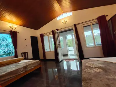 a large room with two beds and windows at Silver Spruce Glass Villa 1BHK Kotagiri in Kotagiri