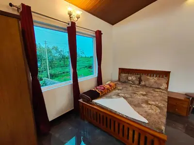 a bedroom with a bed and a large window at Silver Spruce Glass Villa 1BHK Kotagiri in Kotagiri