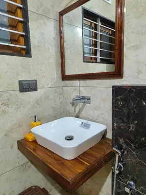 a bathroom with a white sink and a mirror at Ananda Holiday Home in Ambalavayal