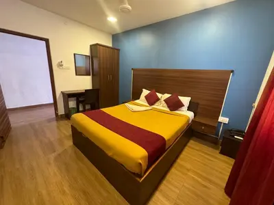 a bedroom with a bed and a table in it at Hotel New Cresent park in Coimbatore