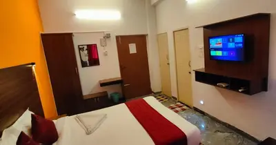 a bedroom with a bed and a tv on a wall at Hotel New Cresent park in Coimbatore