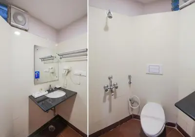a bathroom with a toilet and a sink at THE DAWN HOTEL in Mysore