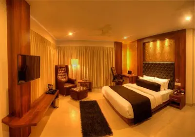 a hotel room with a bed and a chair at THE DAWN HOTEL in Mysore