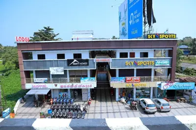 a building with cars parked in front of it at Sky Residency Lodge in Trichūr