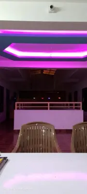 a row of chairs in a room with purple lighting at Sky Residency Lodge in Trichūr
