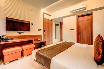 a hotel room with a bed and a desk at Hotel Hari Govindas Mysore - Explore the Heart of Mysore in Mysore