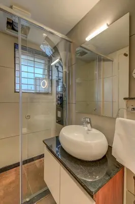 a bathroom with a sink and a glass shower at Hotel Hari Govindas Mysore - Explore the Heart of Mysore in Mysore
