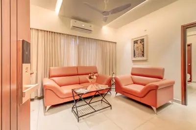 a living room with two chairs and a table at Hotel Hari Govindas Mysore - Explore the Heart of Mysore in Mysore