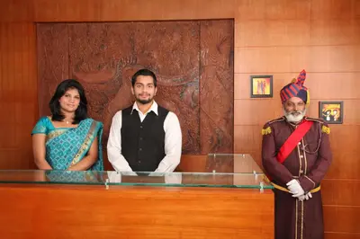 two men and a woman standing next to a counter at Century Grand Hotel in Mananthavady