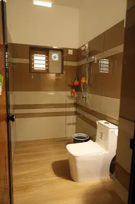 a bathroom with a toilet and a clock on the wall at Le Serene in Meenangadi