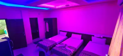 a room with a pink room with a couch and chairs at geo gardens residency in Alwaye