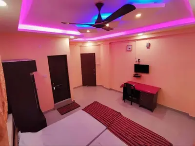 a living room with a ceiling fan and a red rug at geo gardens residency in Alwaye