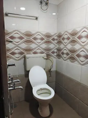 a bathroom with a white toilet in a stall at geo gardens residency in Alwaye