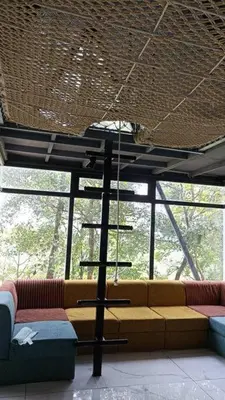 a living room with a couch and a shelf at Wildrootstay 3 bed cottage in Pinangode