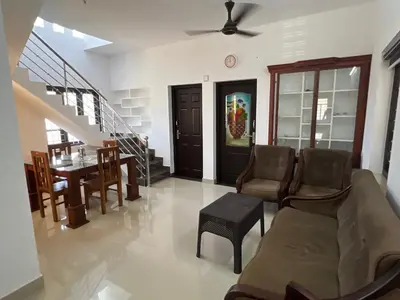 a living room with a couch and a table at Happy Villa Homestay - 2 in Chelakara