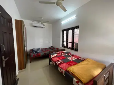 a bedroom with two beds and a window at Happy Villa Homestay - 2 in Chelakara