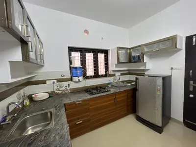 a kitchen with a sink and a refrigerator at Happy Villa Homestay - 2 in Chelakara