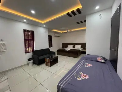 a bedroom with a bed and a living room at RK Residency Calicut in Kozhikode