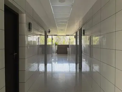 an empty hallway with white tiled walls and a lobby at RK Residency Calicut in Kozhikode