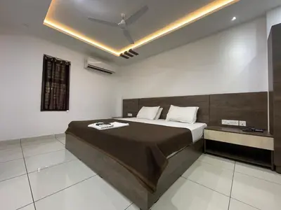 a bedroom with a bed and a ceiling fan at RK Residency Calicut in Kozhikode