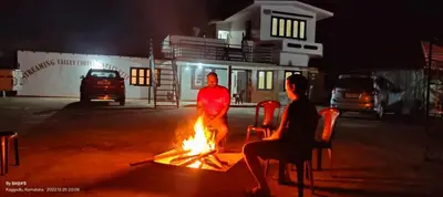 a man standing next to a fire in the street at Streaming Valley Independent Coffee Estate Stay in Madikeri