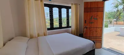 a bedroom with a bed and a large window at Streaming Valley Independent Coffee Estate Stay in Madikeri
