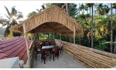 a patio with a table and chairs under a pavilion at Streaming Valley Independent Coffee Estate Stay in Madikeri