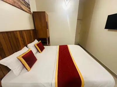 a bedroom with a large bed with two pillows at Rio Rooms Calicut Near Mims Hospital in Kozhikode