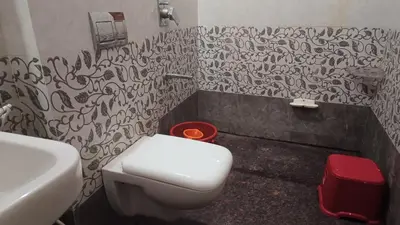 a bathroom with a white toilet and a sink at AR premium family homestay in Mysore