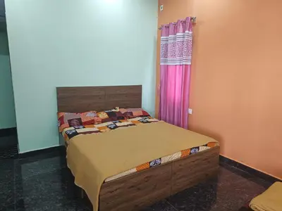 a bedroom with a bed with a wooden headboard at AR premium family homestay in Mysore