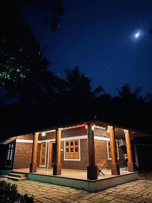 a building at night with the moon in the sky at Happy Land in Shoranūr