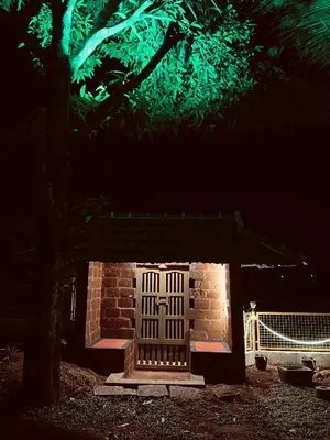a small brick building with a door at night at Happy Land in Shoranūr