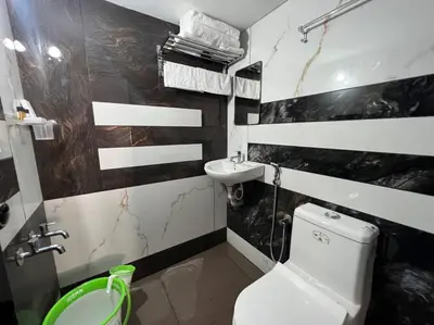a bathroom with a white toilet and a sink at Happy Villa Homestay - 4 in Chelakara