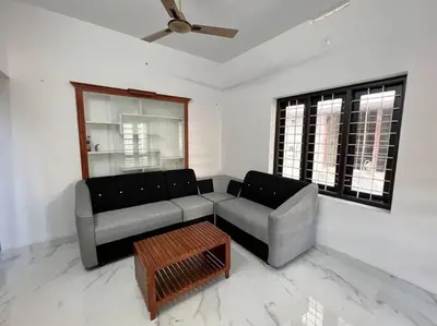 a living room with a couch and a coffee table at Happy Villa Homestay - 4 in Chelakara