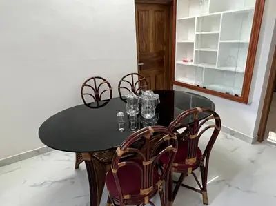 a black table with four chairs and glasses on it at Happy Villa Homestay - 4 in Chelakara
