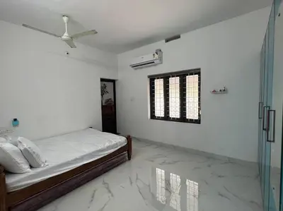 a white bedroom with a bed and a window at Happy Villa Homestay - 4 in Chelakara