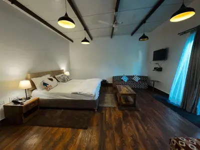 a bedroom with a bed and a couch and a table at Ooty Boulevard in Ooty