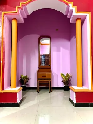 a room with purple walls with a mirror and a dresser at Shivalaya Stays - Coimbatore in Coimbatore