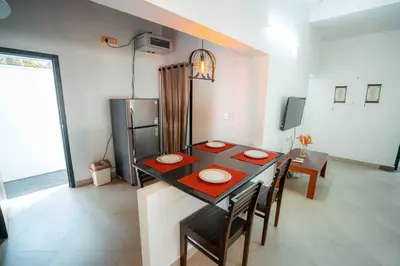a kitchen and dining room with a table and chairs at Cabana by Grha - Charming Cottage at Kappad Beach in Kozhikode