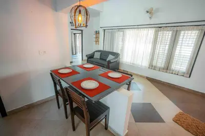 a living room with a table and a couch at Cabana by Grha - Charming Cottage at Kappad Beach in Kozhikode