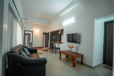 a living room with a couch and a table at Cabana by Grha - Charming Cottage at Kappad Beach in Kozhikode