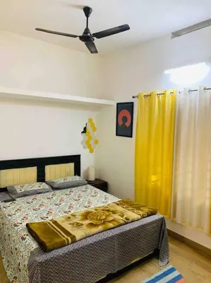 a bedroom with a bed and a ceiling fan at Aanandam - An Independent Villa in 1 Acre Farm in Wayanad