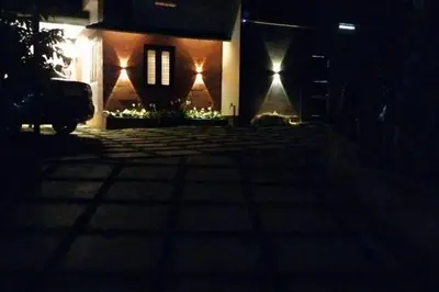 a house with lights on the side of it at night at Aanandam - An Independent Villa in 1 Acre Farm in Wayanad