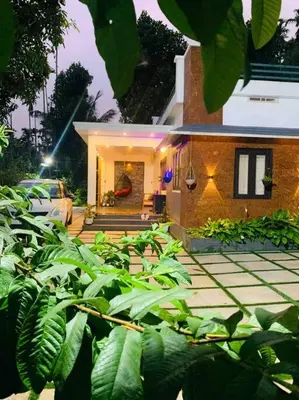 a house with a car parked in front of it at Aanandam - An Independent Villa in 1 Acre Farm in Wayanad