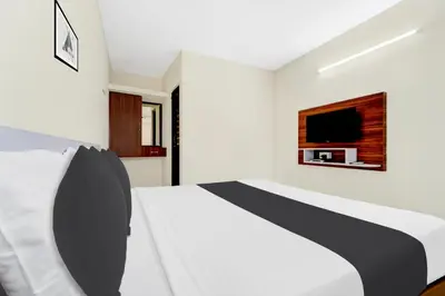 a bedroom with a bed and a tv on the wall at Super Hotel O Avinashi Road Coimbatore in Coimbatore