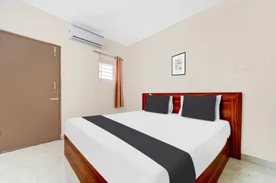 a bedroom with a large bed with black and white sheets at Super Hotel O Avinashi Road Coimbatore in Coimbatore